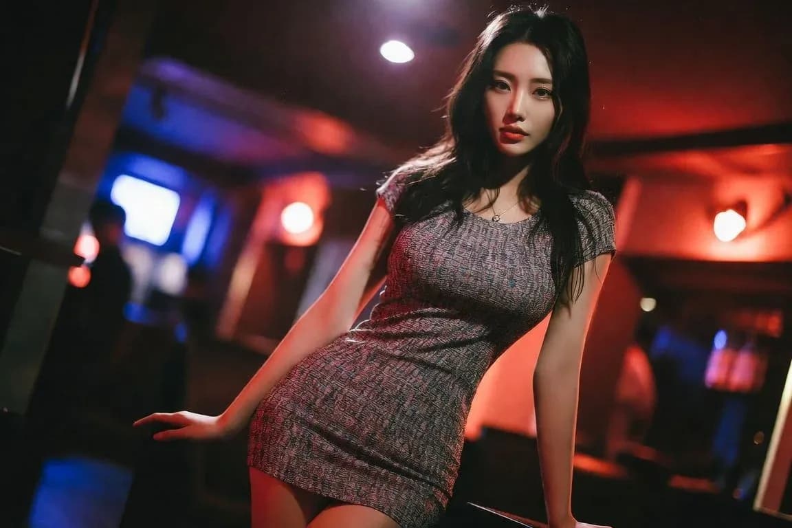 붉은 바 조명 아래 회색 드레스를 입은 여성